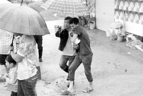 日报二版。图为村干部正在帮助当地受灾群众转移。.jpg 日报二版。图为村干部正在帮助当地受灾群众转移。.jpg